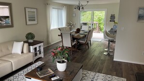 Ein Wohnzimmer mit einer Couch, einem Couchtisch und einem Essbereich mit Stühlen und einem Tisch.