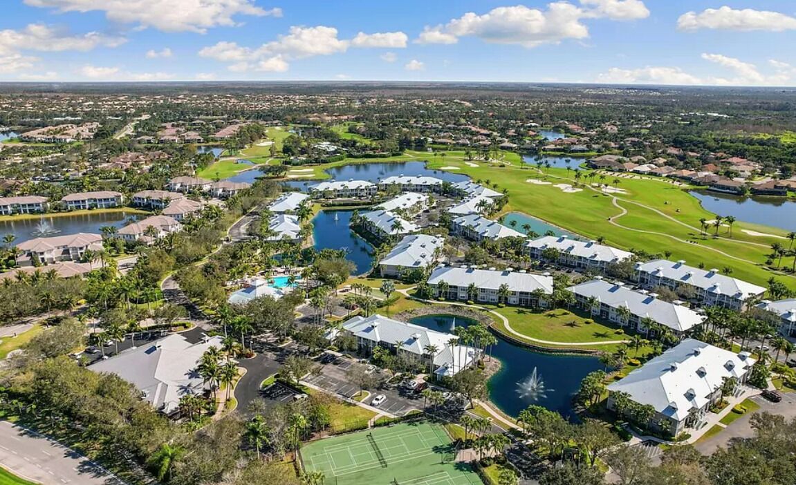 Ein Golfplatz mit Wasserelementen, ein Tennisplatz und Wohngebäude.