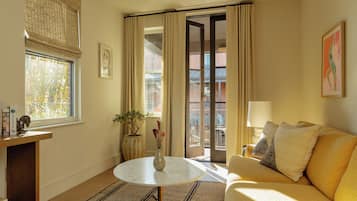 Una sala acogedora con un sofá, una mesa redonda y una planta en maceta.