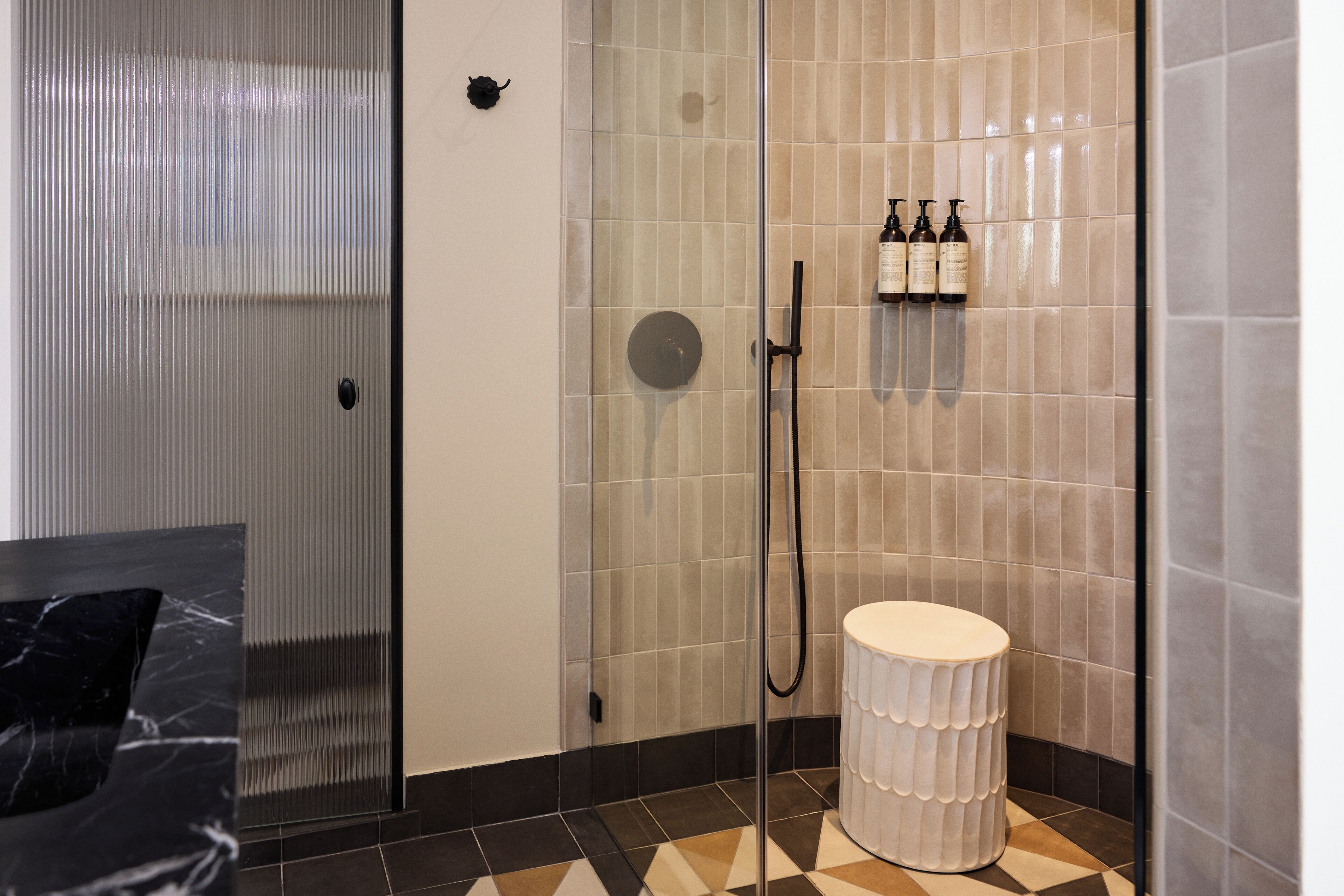 Un baño moderno con cabina de ducha de vidrio, inodoro y lavamanos.