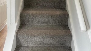 A carpeted staircase with a handrail and a caution sign on the wall. - 4BR Sleeps 9 With Garden and Parking (Birmingham)