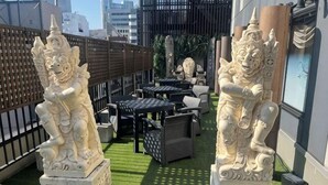 Outdoor seating with statues, a fence, and a building in the background. - Hotel Balian Resort Namba Shinsaibashi - Near Dotonbori (Osaka)