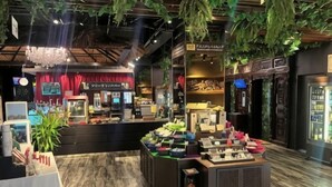 A modern interior with a central display area, wooden ceiling, and hanging plants. - Hotel Balian Resort Namba Shinsaibashi - Near Dotonbori (Osaka)