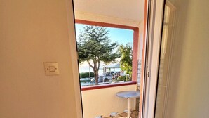 A room with a sliding glass door leading to an outdoor patio with a stone floor, a small table, and a tree. - Sea View Summer Paradise - Emily 1 (Kampor)