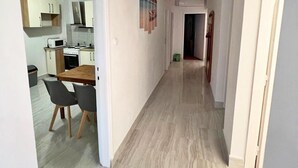 A hallway with a wooden floor, white walls, and a kitchen area visible on the left. - Sea View Summer Paradise - Emily 1 (Kampor)