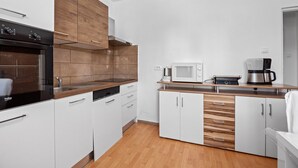 A modern kitchen with white cabinets, wooden accents, a built-in oven, microwave, and coffee maker. - Sea View Summer Paradise - Emily 2 (Kampor)
