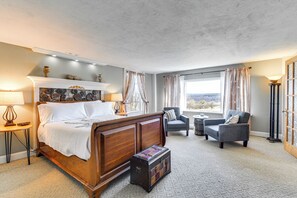 A bedroom with a wooden bed, a small table, a chair, and a suitcase. - Cozy Conesus Vacation Rental Near Wineries & Lake! (Conesus)