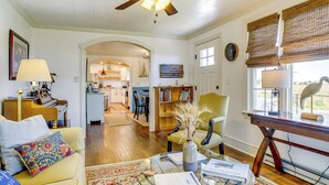 A spacious living room with a ceiling fan, a dining area, and a kitchen in the background. - Unique Tangier Cottage w/ Chesapeake Bay Views! (Tangier)
