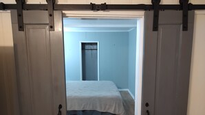 Una habitación con cama, una puerta y un armario.