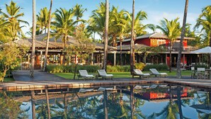 A resort with a pool surrounded by palm trees and lounge chairs. - Fazenda São Francisco do Corumbau (Prado)