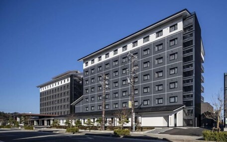A modern hotel with a multi-story structure, featuring a mix of window types and a prominent entrance with a covered area.