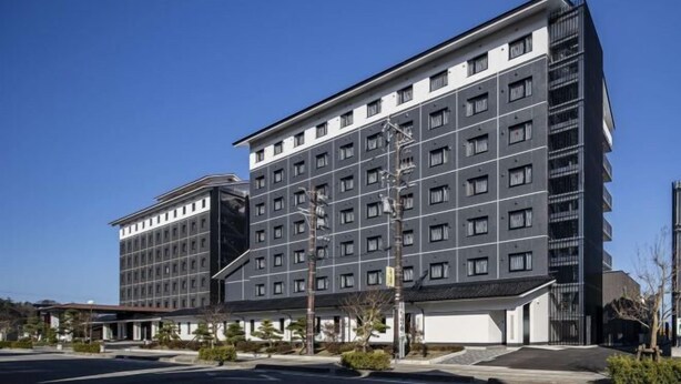 A modern hotel with a multi-story structure, featuring a mix of window types and a prominent entrance with a covered area. - Hotel Route-Inn Wajima (Wajima)