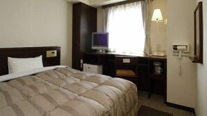 A hotel room with a bed, a desk with a computer, a television, and a window with curtains. - Hotel Route-Inn Wajima (Wajima)