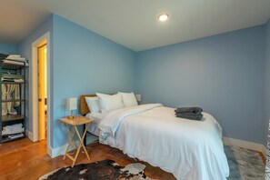 A bedroom with a bed, bedside table, lamp, and a wardrobe.