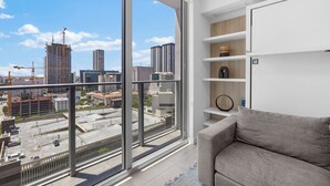A modern apartment with a large balcony, city views, and a minimalist interior.