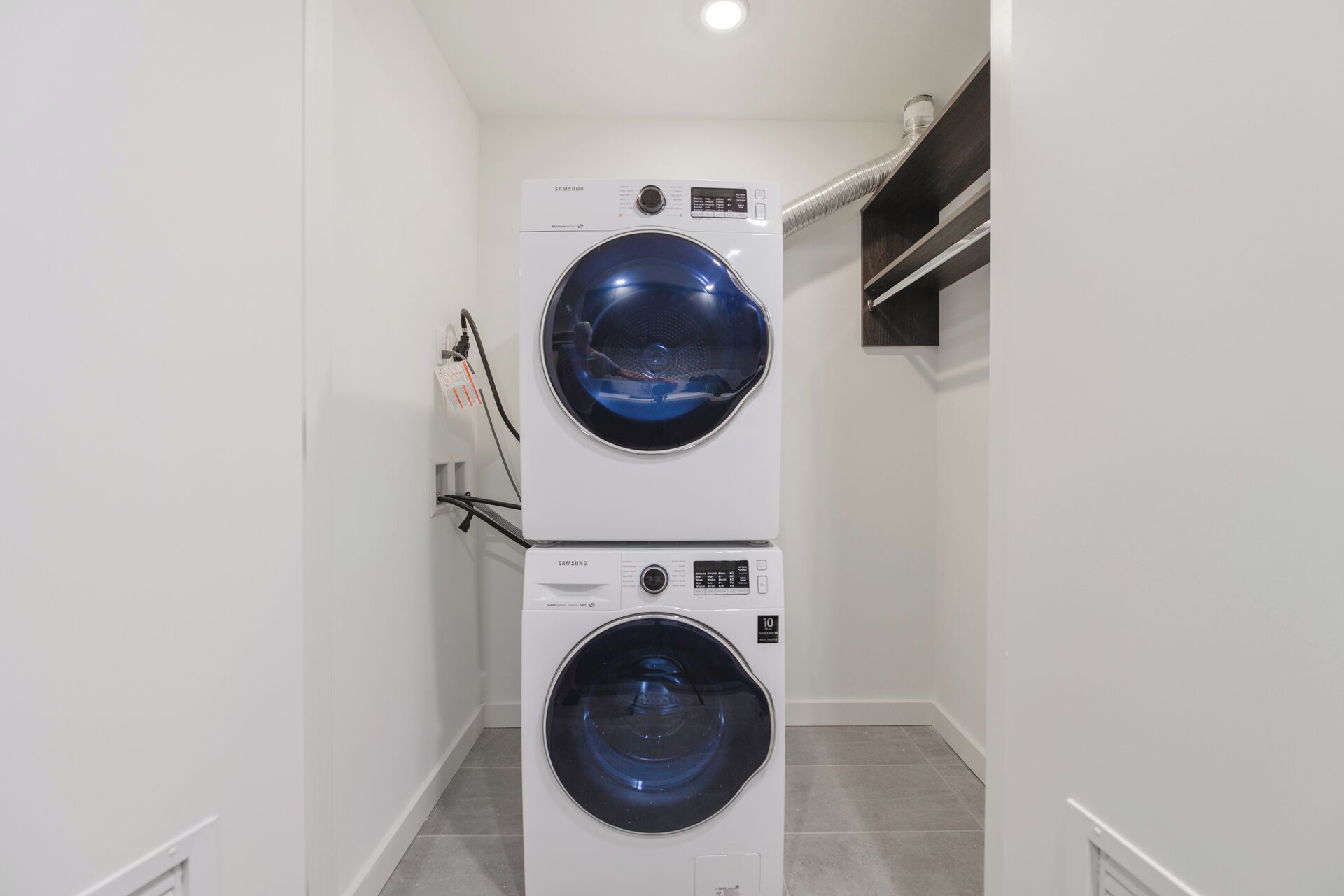 Une buanderie équipée de deux machines à laver Samsung superposées.