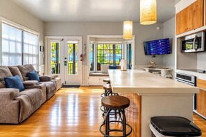 A modern kitchen with a central island, bar stools, and a flat-screen TV. - Villas De Isla Bonita (San Pedro)