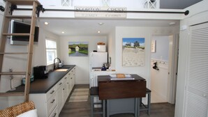 Una cocina compacta con un banco de madera, una escalera y un cartel que indica la ubicación como Scorton Creek.