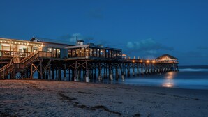 A pier extending into the ocean with a building on it. - Oceanfront Balcony-Private Beach Access-Heated Pool (Cape Canaveral)