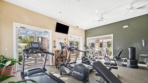 Een fitnessruimte met loopbanden, elliptische trainers en gewichtbanken.