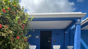 A blue building with a staircase leading to a door marked "427". - Casa Lluavi (Mérida)