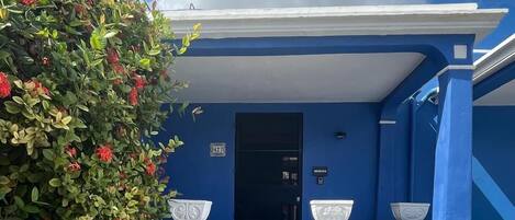 Un edificio azul con una escalera que lleva a una puerta con el número 427.