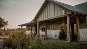 Un bâtiment doté d’un toit en pente, d’un porche en bois et de jardinières suspendues.