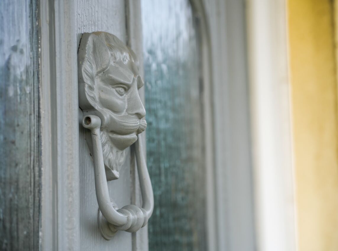 A stone door knocker with a lion's head design.