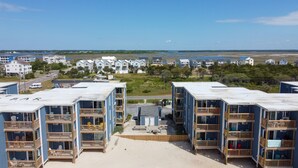 Een strandpand met meerdere blauw-witte gebouwen, elk met balkons en buitenplaatsen.