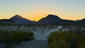 Un paysage désertique avec des montagnes au coucher du soleil.