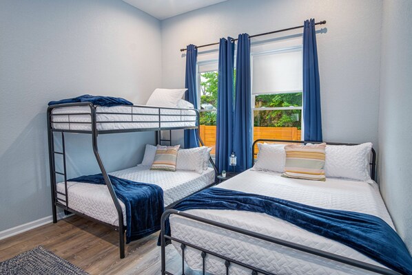 Una habitación con literas, una ventana con cortinas y vistas al exterior.