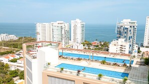 A high-rise building with a rooftop pool and a view of the sea. - salguero suite 313 (Santa Marta)