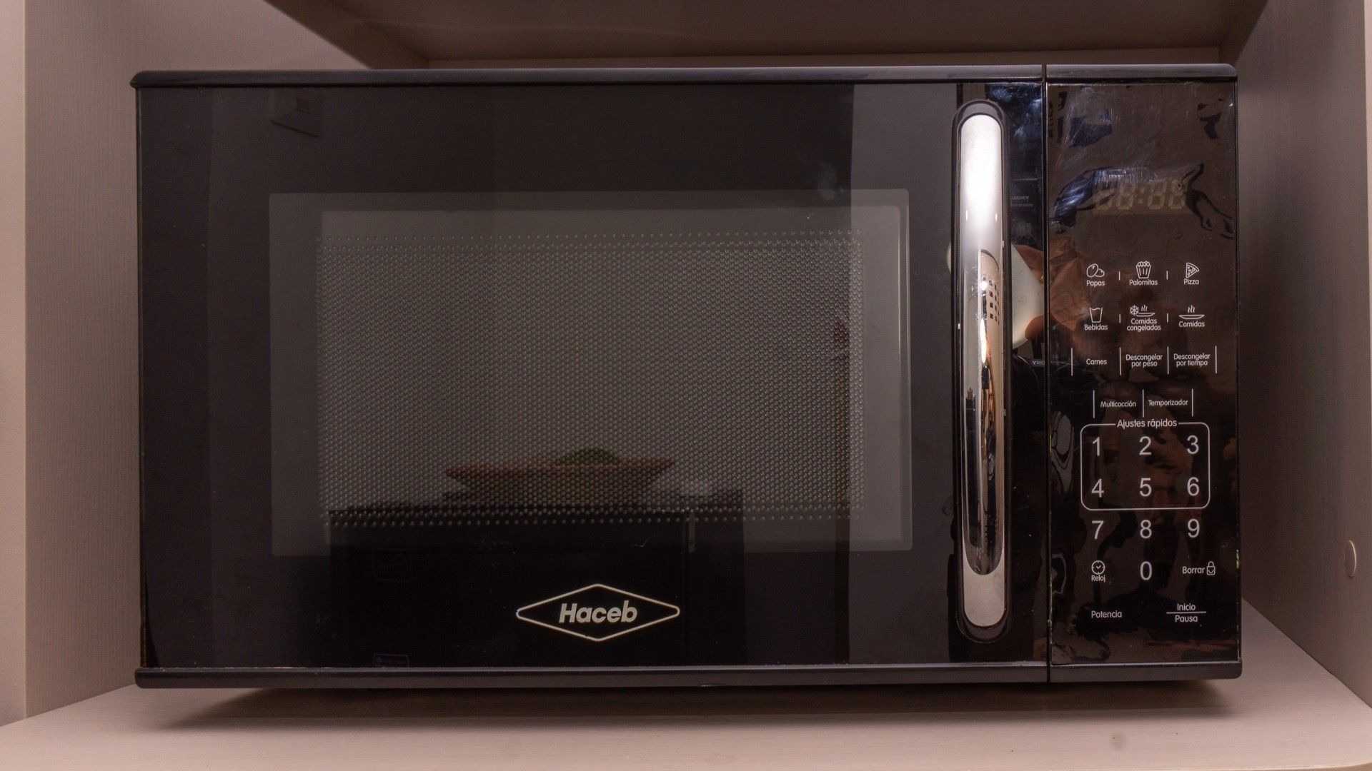 A black microwave with a digital control panel and the brand name 'Hacib' visible on the front.