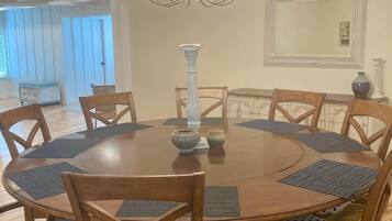 Enjoy meals in this dining room with a round table and six chairs, a chandelier, and a mirror.