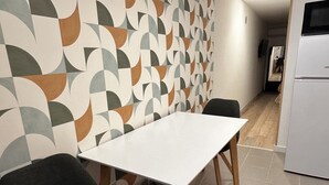 A small kitchen with a white table and two chairs.