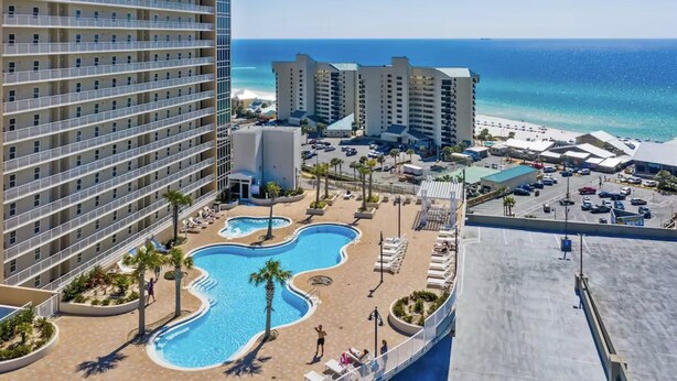 A hotel with multiple floors, a swimming pool, and a view of the beach. - Laketown Wharf 1120 (Panama City Beach)
