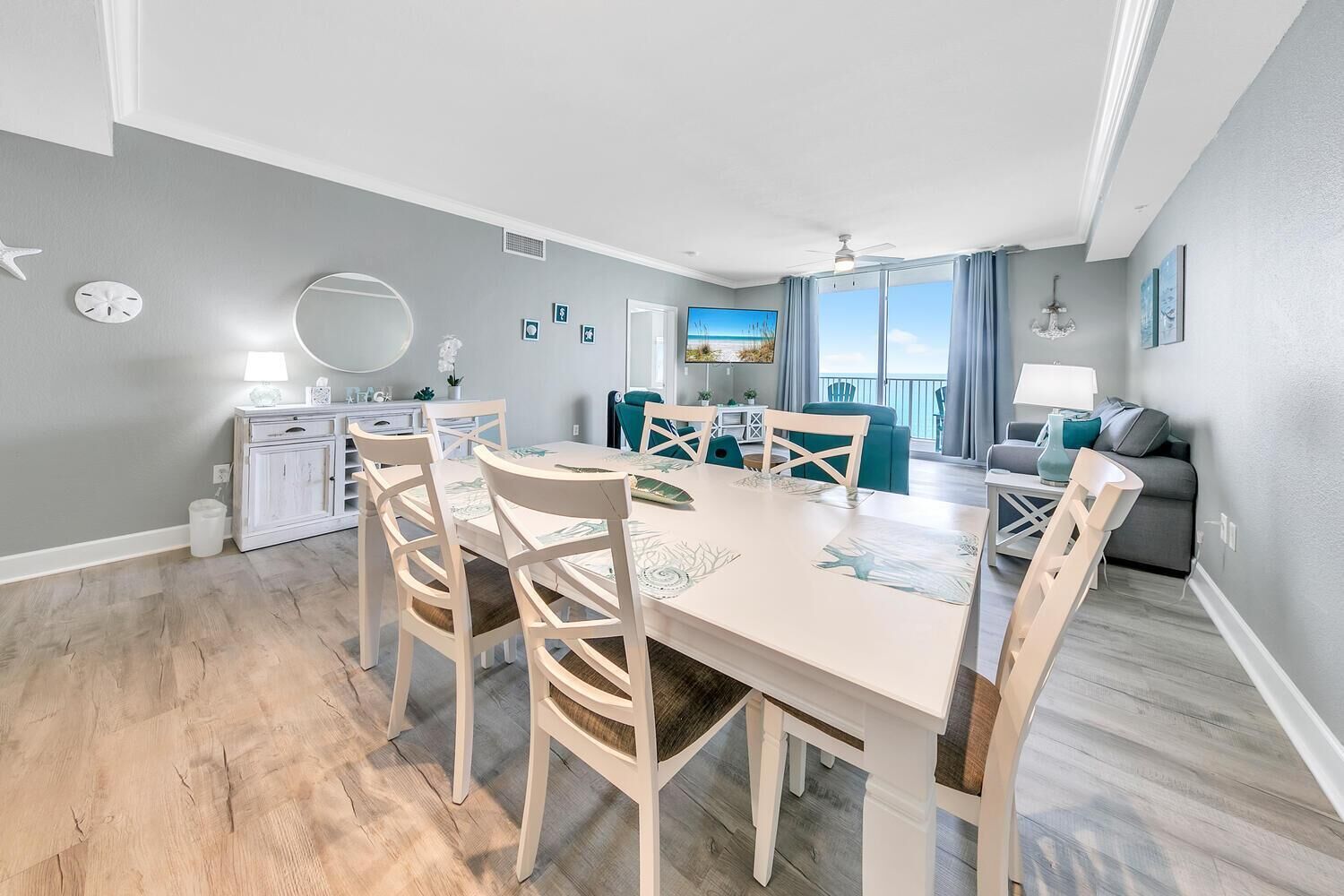 Una sala de estar moderna con comedor, un sofá y vista al océano.
