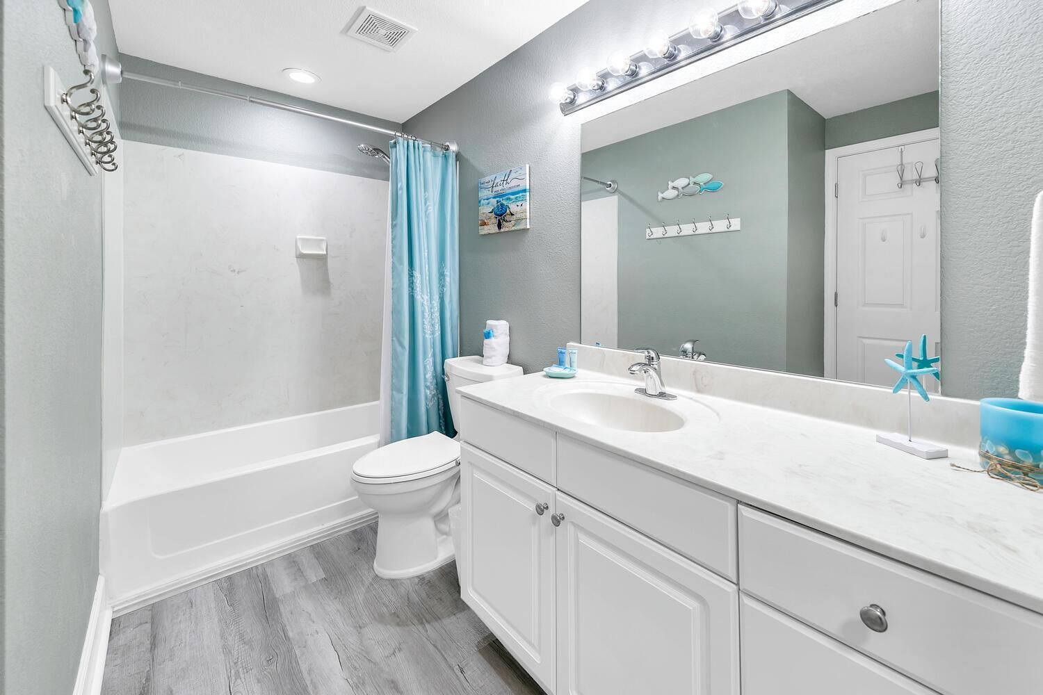 A modern bathroom with a bathtub, toilet, and vanity with a sink.