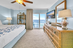 Relax in this serene room with a large bed, ceiling fan, and ocean views.