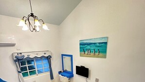 A room with a blue and white bed, a window with a view, a painting of penguins, and a ceiling light. - Ians Home (Dongshan)