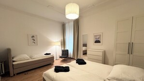 Ett hotellrum med en stor säng, en stol, ett skrivbord och en garderob.