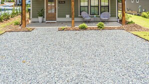 A two-story house with a covered porch, a front door, and two windows on the upper floor. - The Cowboy (Southern Pines)