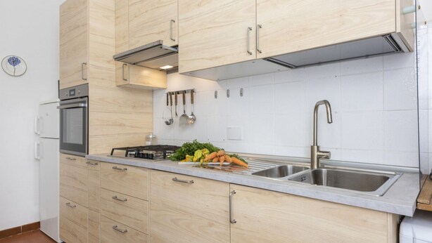 Une cuisine moderne avec des meubles en bois, des appareils en acier inoxydable et un évier à deux bacs.
