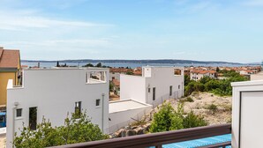 A residential area with white buildings, a clear view of the sea, and a distant mountain range. - 1 bedroom nice apartment in Kastel Kambelovac (Kastel Kambelovac)
