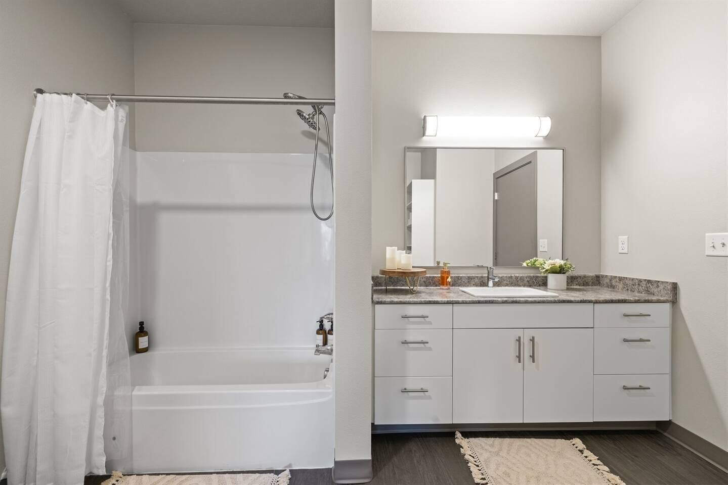A bathroom with a shower, a sink, and a mirror.