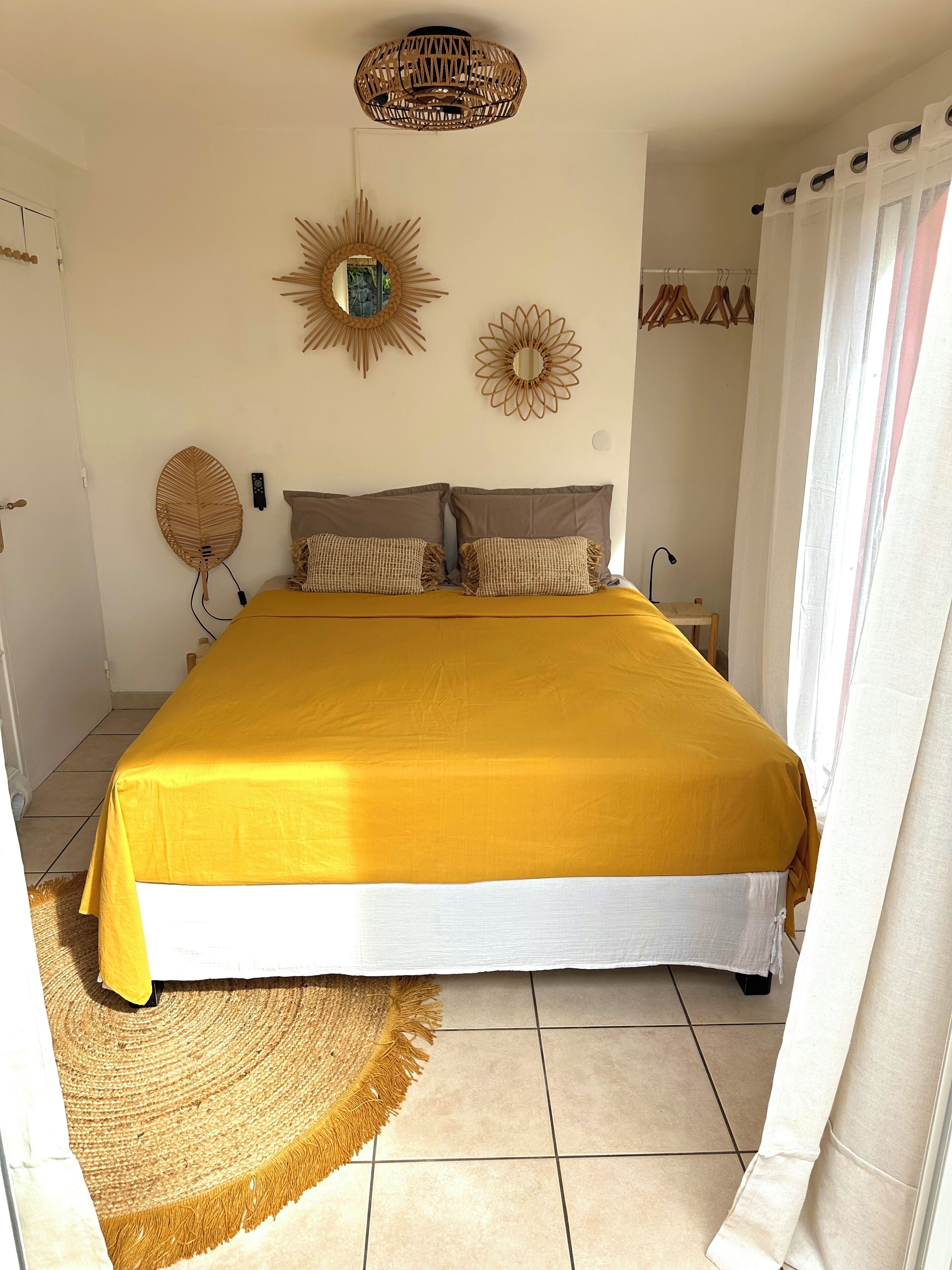 Een slaapkamer met een groot bed, een spiegel aan de muur en decoratieve wandkunst.