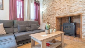 A living room with a grey sofa, a wooden coffee table, and a fireplace. - Villa Madrid Alcazar El Gastor by Ruralidays (Cádiz)