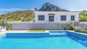 A swimming pool with a view of a mountain and a white building with a tiled roof. - Villa Madrid Alcazar El Gastor by Ruralidays (Cádiz)
