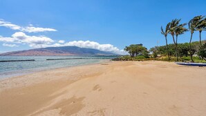 A sandy beach with a clear view of the ocean and distant mountains. - Amazing Oceanfront Views! MS420 (Kihei)