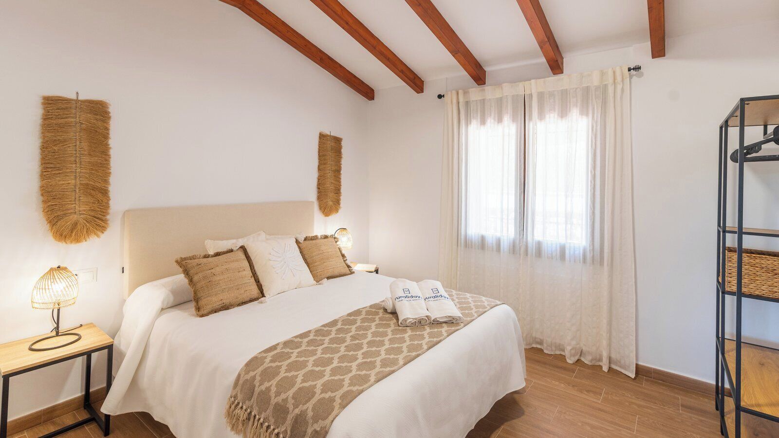 Une chambre à coucher avec un lit, des tables de chevet, une lampe et une armoire.